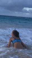 9yo girl in bikini playing in the ocean at dusk