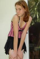 cute redhead with braces in pink top and black skirt